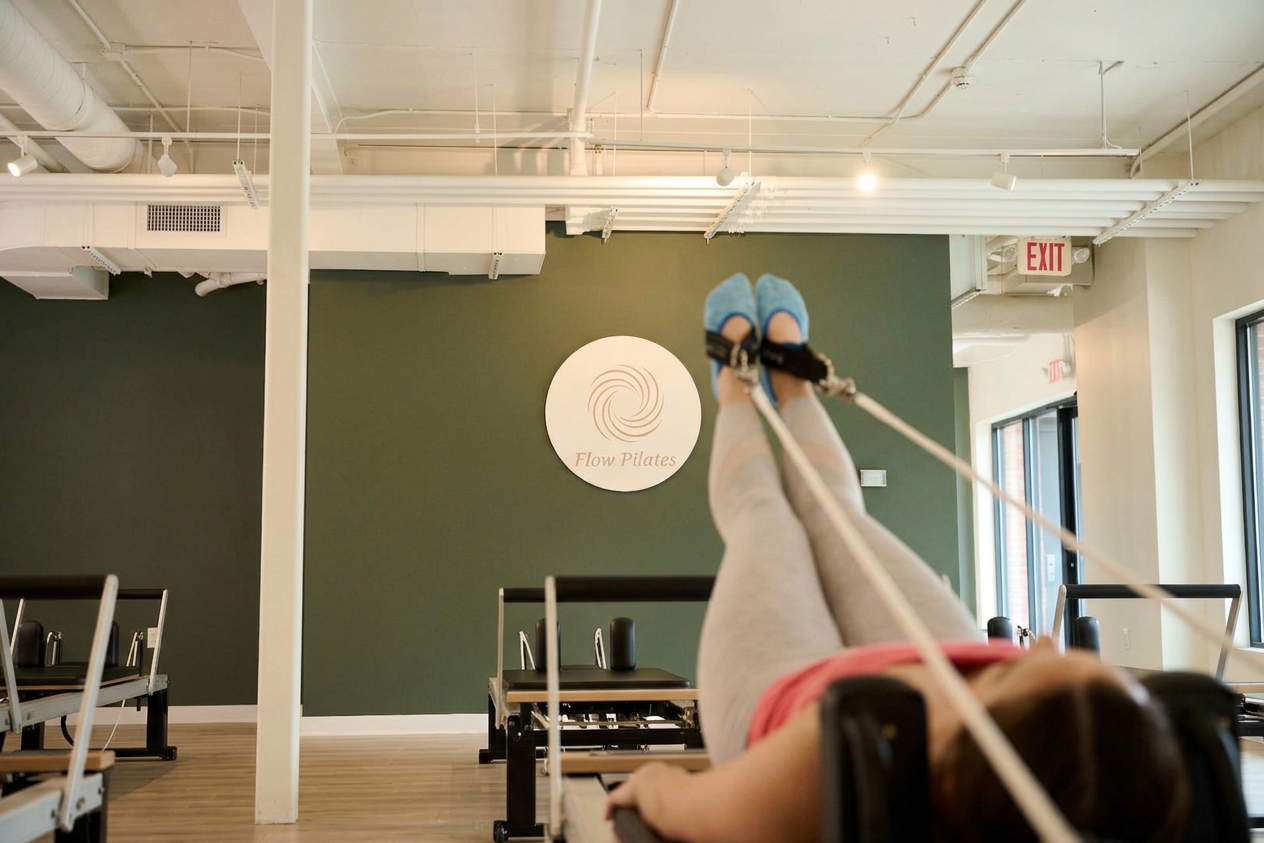 Woman doing reformer pilates at Flow Pilates Chapel Hill